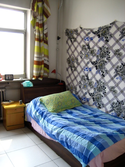 And finally my room. I have a blanket on my wall because the walls are not painted so the white dusty plaster rubs off when you touch them. My bed is comfy enough. I have become used to the hard mattresses Chinese people are accustomed to.